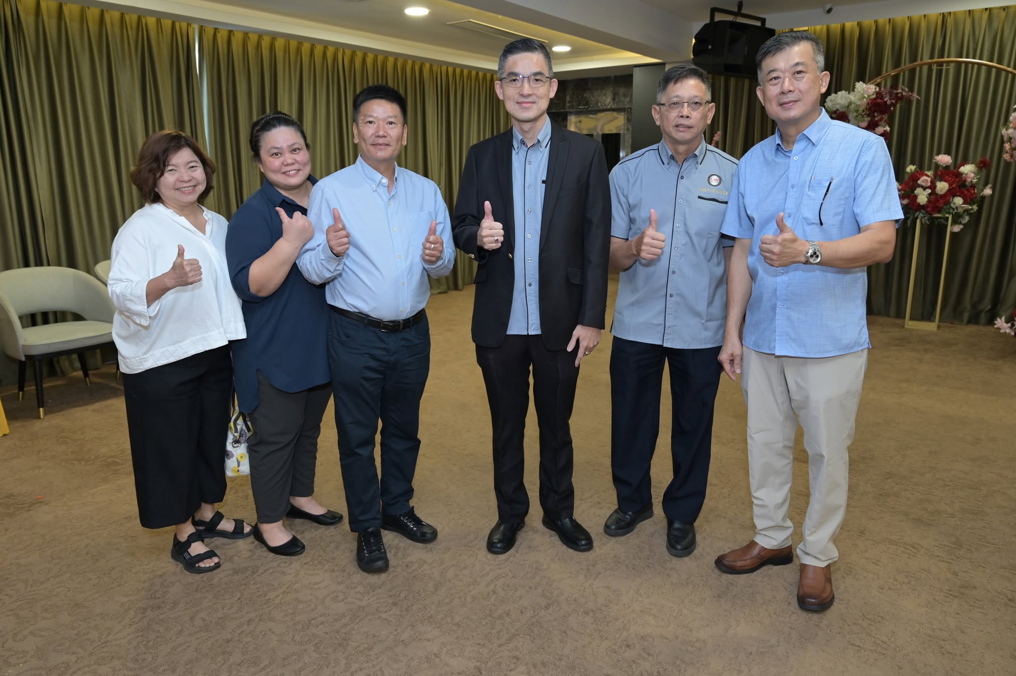 Committee members and guests giving thumbs up in a Klang ballroom